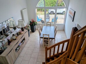Ein Essbereich mit Tisch, Stühlen und einer Holzbank, sowie einem Blumentopf.
