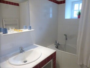 A bathroom with a white sink, a mirror, a shower, and a window with a plant. - Spacious house in nature - 10 guests (Mazerat-Aurouze)