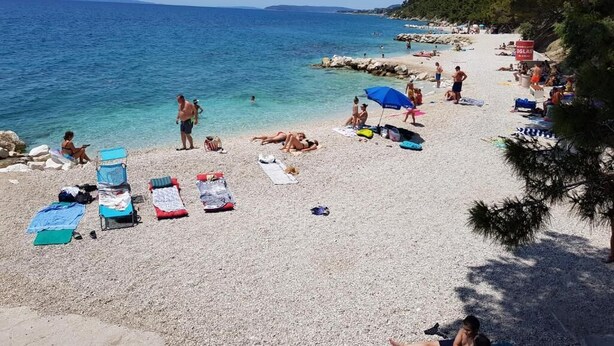 A beach with people sunbathing, swimming, and walking along the shore. - MARIO-50m from the beach,big terrace with sea view. FREE PARKING (Stobreč)