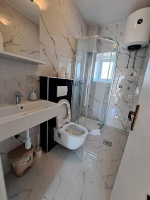 A modern bathroom with a marble floor, a white sink, a toilet, and a glass shower enclosure. - MARIO-50m from the beach,big terrace with sea view. FREE PARKING (Stobreč)