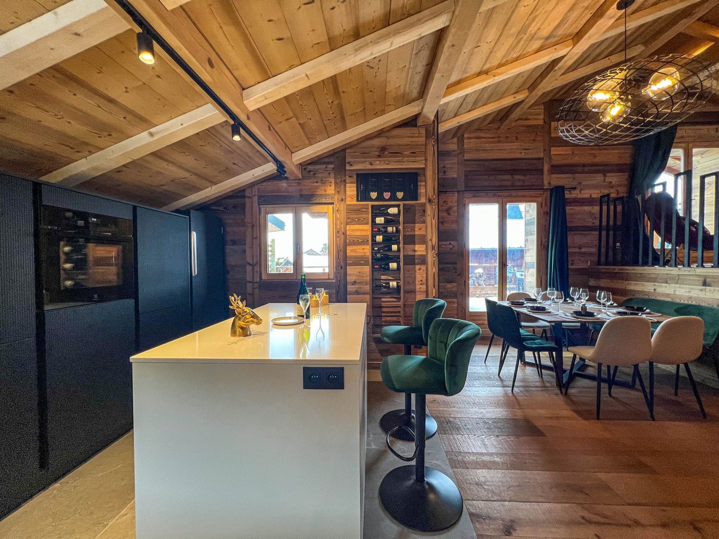 A wooden interior with a bar area, seating, and a view through a window.