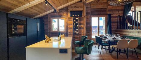 A wooden interior with a bar area, seating, and a view through a window.