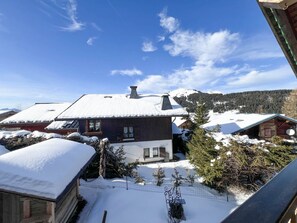 Schneebedeckte Landschaft mit einer Holzhütte und einem Haus mit geneigtem Dach.