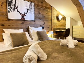 Une pièce avec un mur en bois, un lit avec des oreillers, un bureau et une chaise.