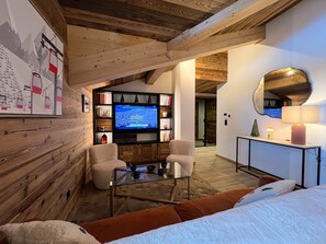 Un salon moderne avec un téléviseur, des sièges et un plafond en bois.