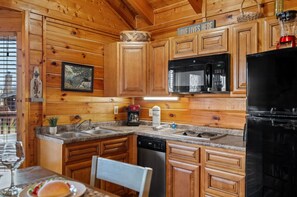 Una cocina con armarios de madera, microondas, refrigerador y lavavajillas.