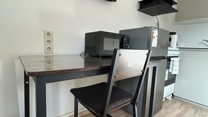 A compact kitchenette with a microwave, coffee maker, and a small refrigerator. - Vrbo Property (Essen)