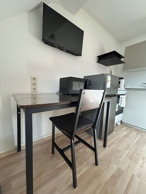 A compact kitchenette with a microwave, coffee maker, and a small refrigerator. - Vrbo Property (Essen)