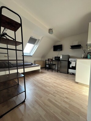 A compact room with a bunk bed, kitchenette, and a small dining area. - Vrbo Property (Essen)