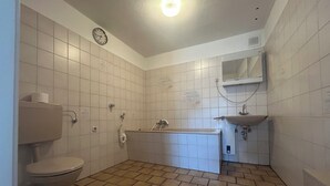 A bathroom with a toilet, a bathtub, and a sink. - Vrbo Property (Essen)