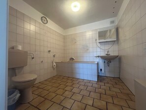 A bathroom with a toilet, a bathtub, and a sink. - Vrbo Property (Essen)