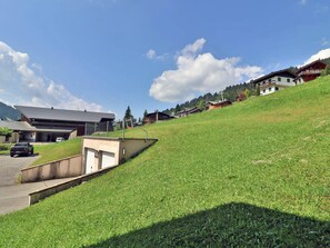 Ein Wohngebiet mit Häusern an einem Hang, einem Parkplatz und einem wolkenlosen Himmel.