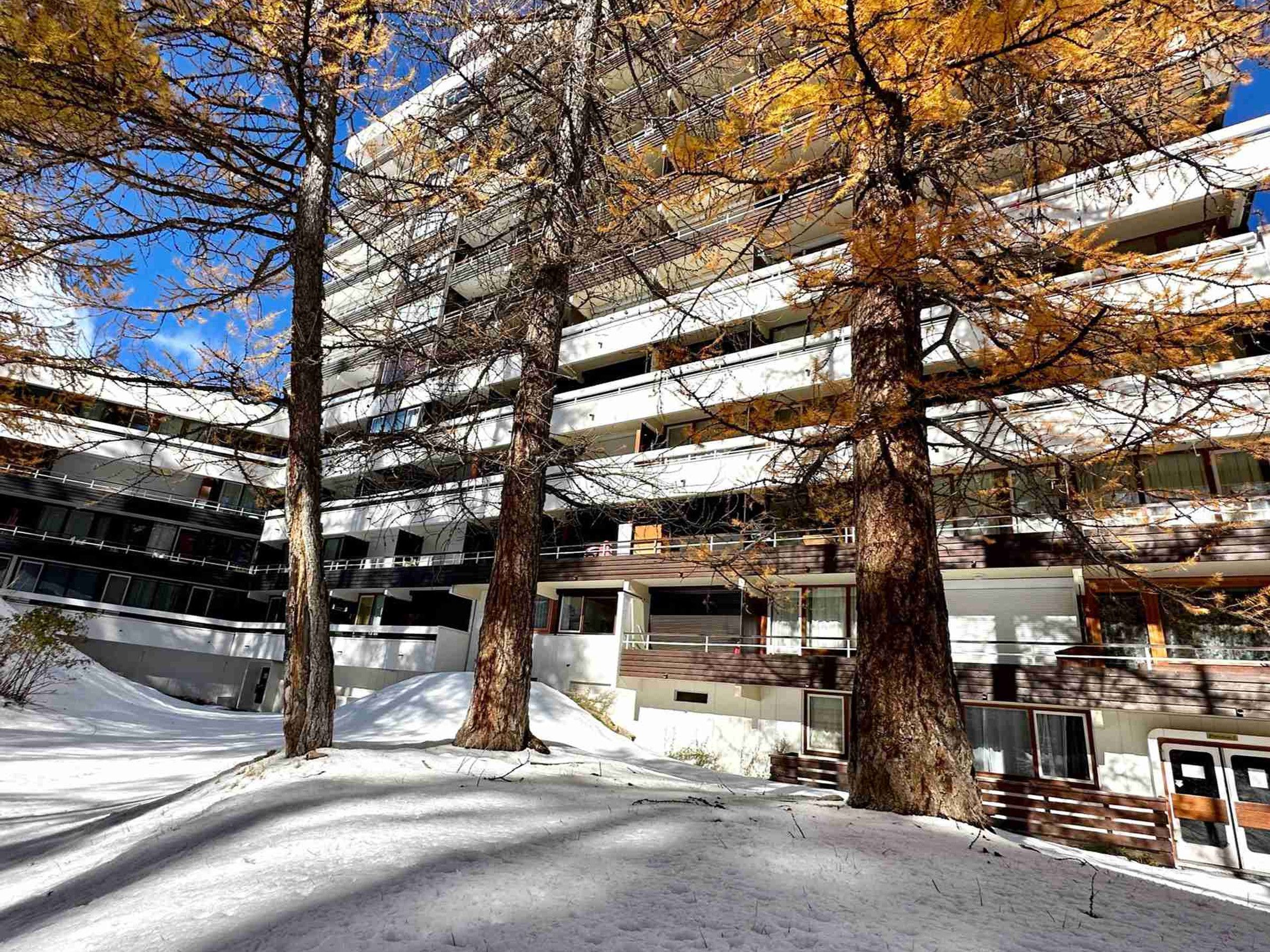 A multi-story building with a modern architectural design, featuring balconies and large windows.