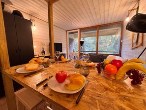Una mesa de madera con platos de comida, vasos y cubiertos.