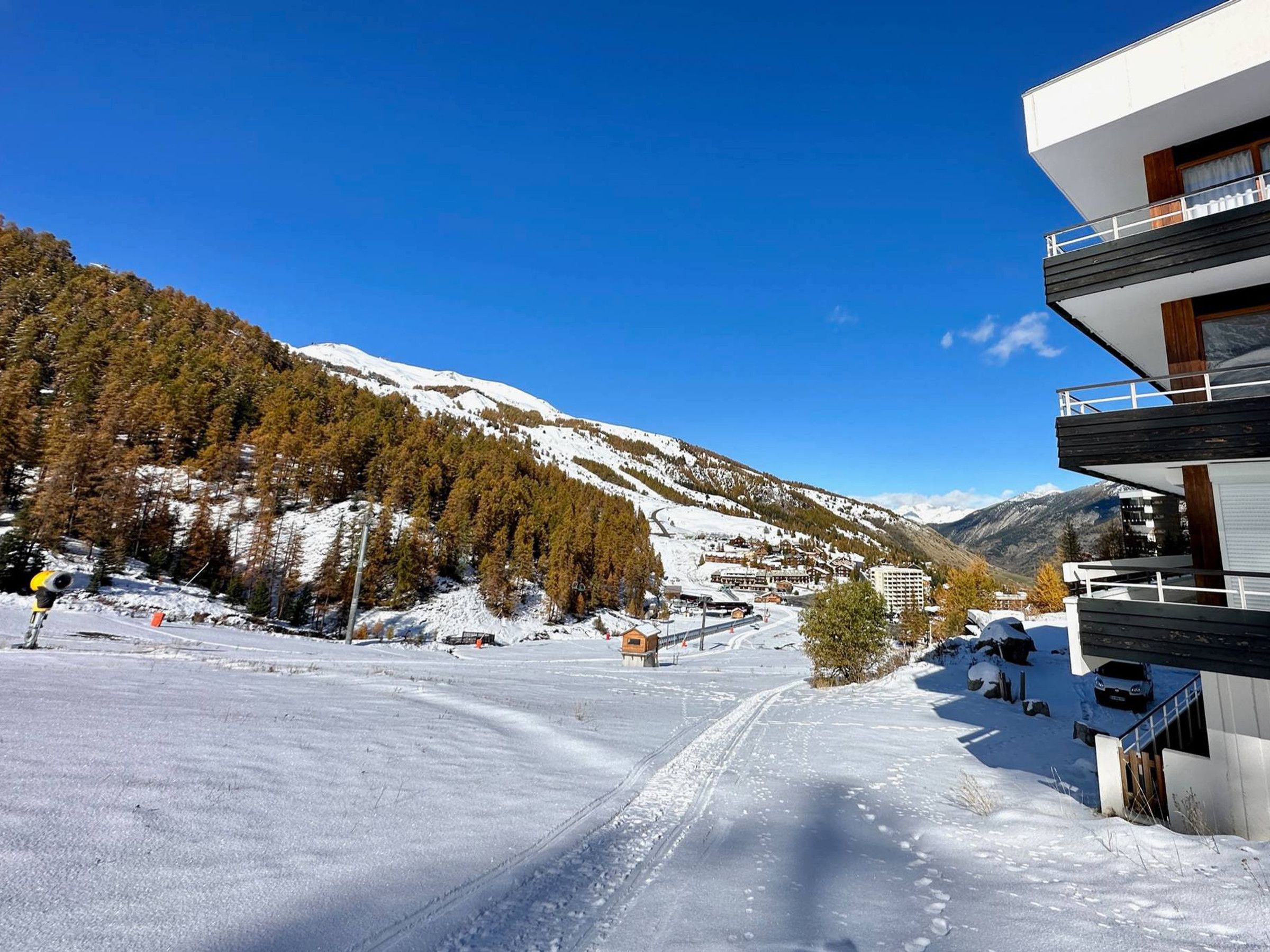 A modern building with a ski slope in the background.