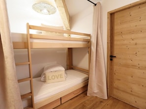 A bunk bed with a pillow that has 'LOVE' written on it, a wooden door, and a ceiling fan. - Comfortable apartment - 4 guests (Les Gets)