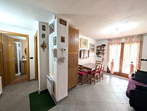 A compact living space with a kitchenette, dining area, and a sofa.