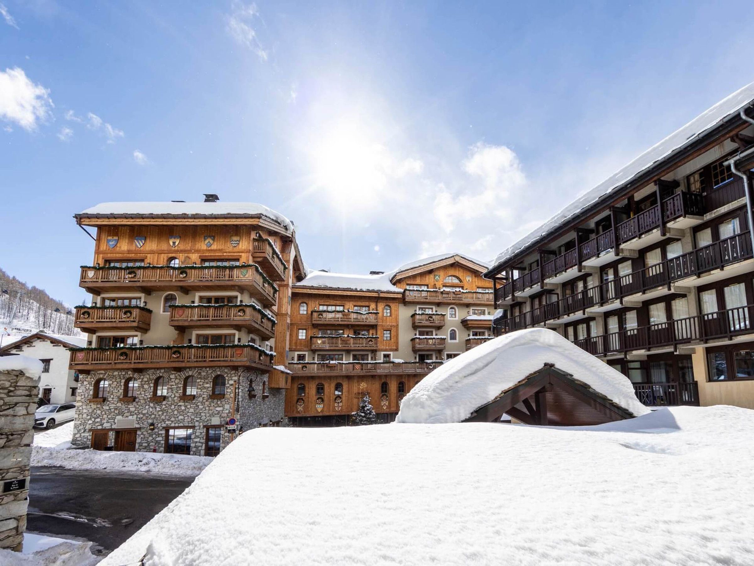 A snow-covered building with multiple balconies and a stone facade.