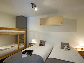 A room with bunk beds, a bedside table with a lamp, a wooden cabinet, and a teddy bear on one bed. - Charming apartment at foot of slopes - 6 guests (Les Deux Alpes)