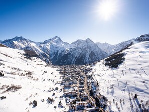 A snow-covered mountain town with a clear view of the surrounding peaks and a bright sun in the sky. - Ideal ski-in/ski-out apartment - 6 guests (Les 2 Alpes 1650)