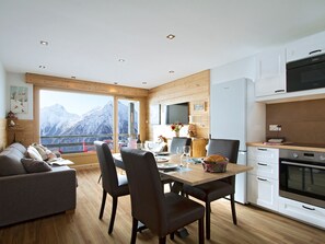 A modern kitchen with white cabinets, a black microwave, and an oven. - Apartment with view of La Muzelle - 4 guests (Les Deux Alpes)