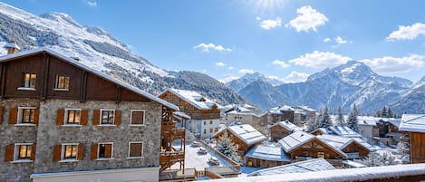 A snow-covered mountain village with wooden buildings and a clear sky.