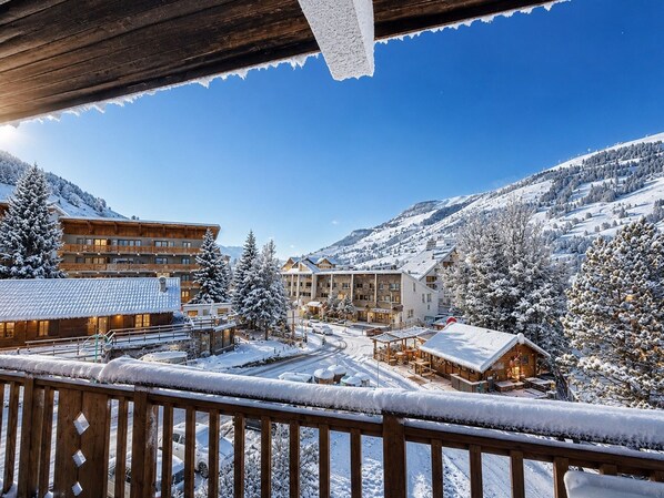 A snowy mountain resort with wooden buildings and a clear blue sky. - Cozy duplex, near slopes - 8 guests (Les Deux Alpes)