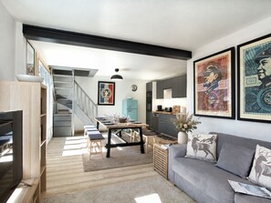 A modern living space with a dining area, kitchen, and staircase. - Cozy duplex, near slopes - 8 guests (Les Deux Alpes)