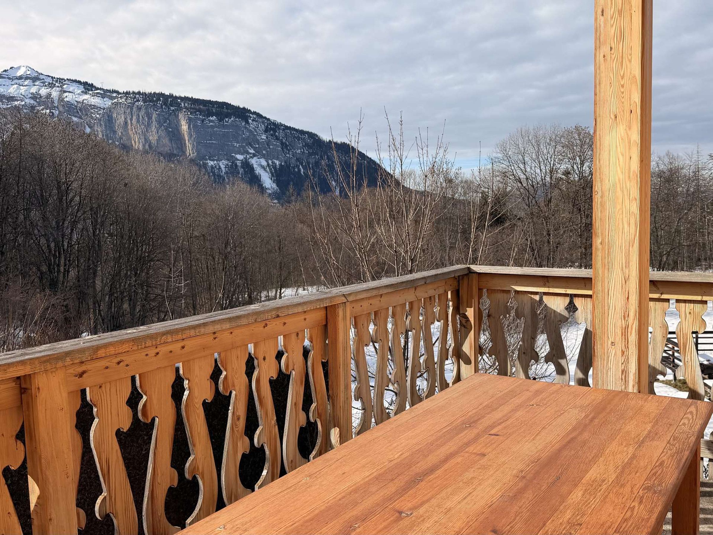 Eine Holzterrasse mit Blick auf ein Gebirge.