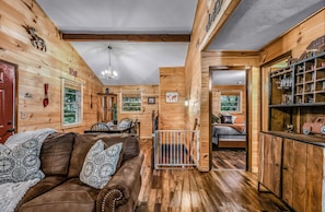 A cabin interior with a wooden interior, a dining area, and a bedroom with a view. - Your Home Away From Home 3 bedrooms, 2 bathrooms, 7 minutes to Pigeon Forge (Sevierville)