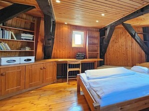 A wooden room with a bed, a desk, and bookshelves. - F.-house Fh10 "the Old Mill" (Graal Mueritz)