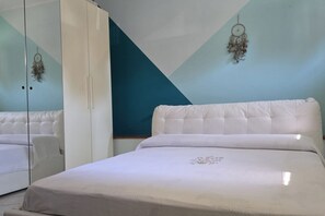 Una camera da letto con un letto, un armadio e uno specchio.