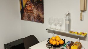 A small dining area with a table, chairs, a painting on the wall, a bowl of oranges, and a bag of chips. - Three bedrooms with parking and security. (Buenos Aires)