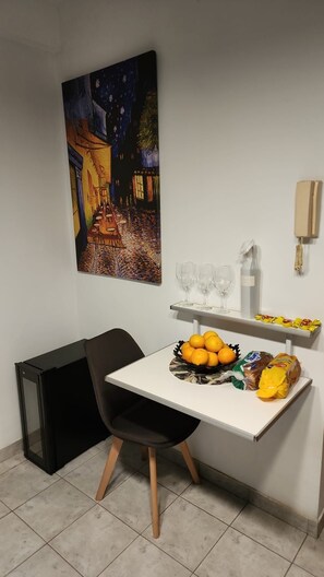A small dining area with a table, chairs, a painting on the wall, a bowl of oranges, and a bag of chips. - Three bedrooms with parking and security. (Buenos Aires)