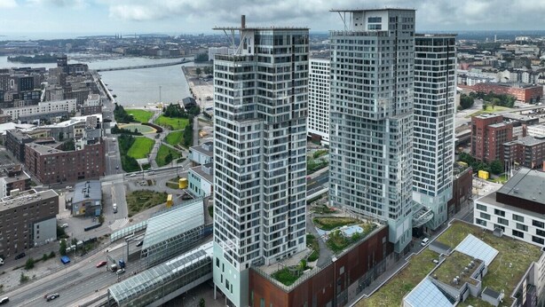 A high-rise building with a modern architectural design, featuring a glass facade and a rooftop garden. - Kalasatama apartments by Come in (Helsinki)