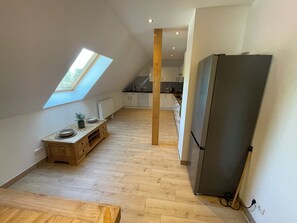 A modern kitchen with a skylight, wooden flooring, and a built-in refrigerator. - Ferienwohnung für bis zu 6 Personen in Plattenburg (Plattenburg)