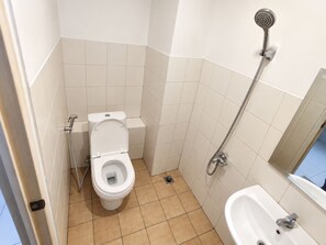 A small bathroom with a toilet, a shower, and a sink. - Apartment Mahakam by Buka Kamar (Bekasi / Jawa Barat)