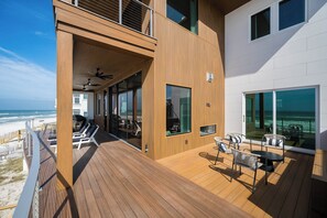 Une terrasse avec des sièges et une vue sur l’océan.