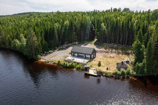 A cabin with a dock extending into a lake, surrounded by dense forest. - Lakeside cabin on its own peninsula—completely secluded (hällefors)