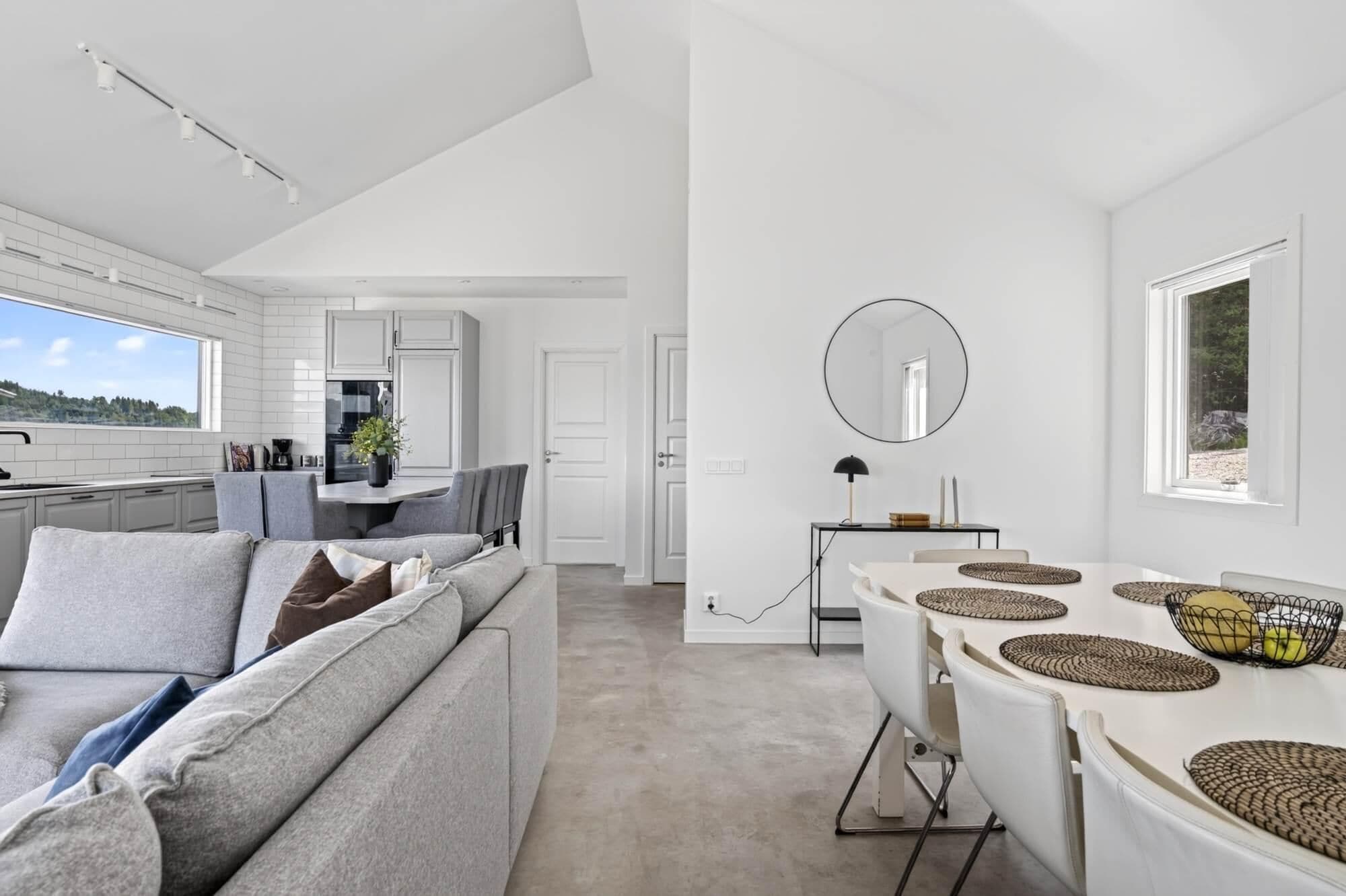 Un intérieur moderne comprenant un canapé, une table à manger et un coin cuisine.
