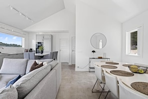 A modern interior with a sofa, dining table, and kitchen area. - Lakeside cabin on its own peninsula—completely secluded (hällefors)