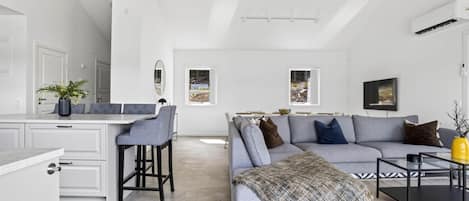 Un espace de vie moderne comprenant un coin repas, un ensemble de canapés et une table basse.