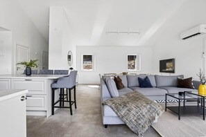 A modern living space with a dining area, a sofa set, and a coffee table.