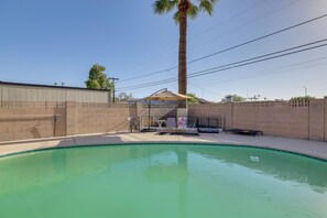 A swimming pool with a palm tree, lounge chairs, and a covered seating area. - Shared Pool! Phoenix Studio Near Hospital (Phoenix)