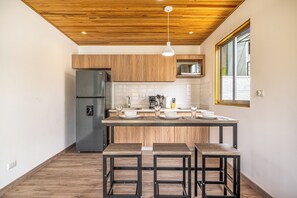 Eine moderne Küche mit Holzausstattung, einer eingebauten Mikrowelle und einer Theke mit Sitzgelegenheiten.