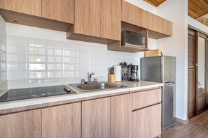 A modern kitchen with wooden cabinets, stainless steel appliances, and a large window. - Private 2-studio Retreat Near Playa Del Coco! (Sardinal)