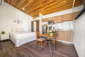 A compact living space with a bed, a dining table with chairs, a kitchenette, and a wooden ceiling. - Private 2-studio Retreat Near Playa Del Coco! (Sardinal)