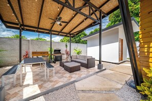 An outdoor patio area with a ceiling fan, a barbecue grill, and a seating arrangement including a table and a sofa. - 'veranera' Condo w/ Pool Access, 1/2 Mi to Beach! (Sardinal)
