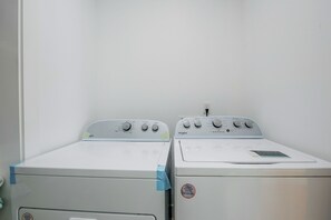 Dos secadoras Whirlpool blancas una al lado de la otra en un cuarto de lavado con una pared blanca lisa.