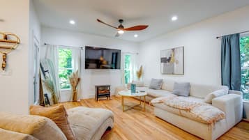 A modern living room with a sofa, a coffee table, and a television.